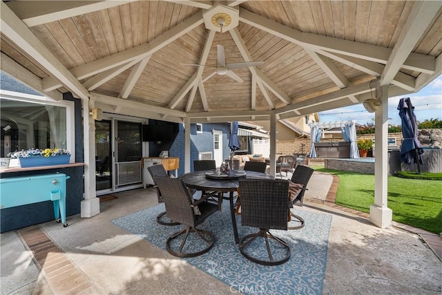 view of patio with a gazebo, outdoor dining space, and fence