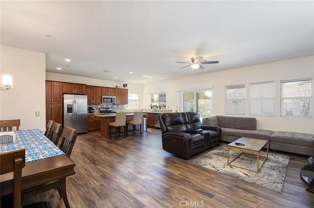 living area featuring dark wood finished floors, a ceiling fan, and recessed lighting