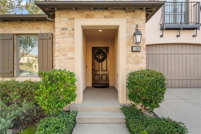 doorway to property featuring stone siding and a balcony