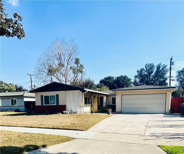 ranch-style home featuring an attached garage, a front lawn, concrete driveway, and stucco siding