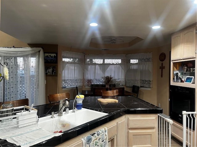 kitchen featuring tile countertops, recessed lighting, light brown cabinets, and oven