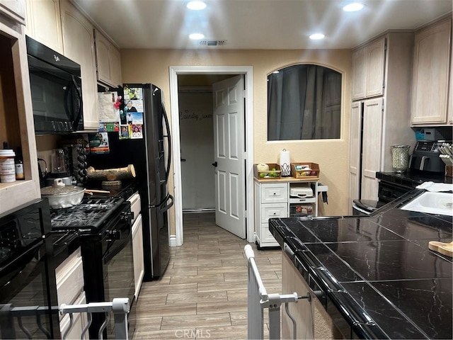 kitchen featuring visible vents, dark countertops, wood tiled floor, black appliances, and recessed lighting