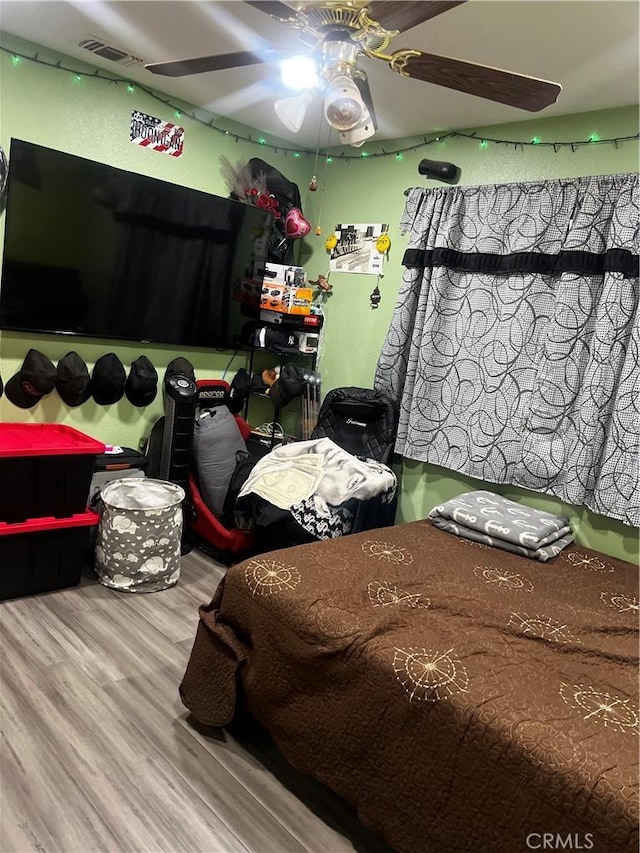 bedroom with visible vents, ceiling fan, and wood finished floors