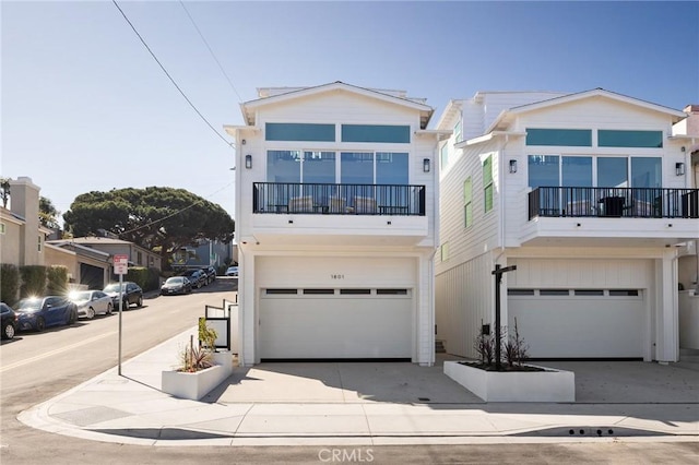 view of front of property with driveway, a balcony, and an attached garage