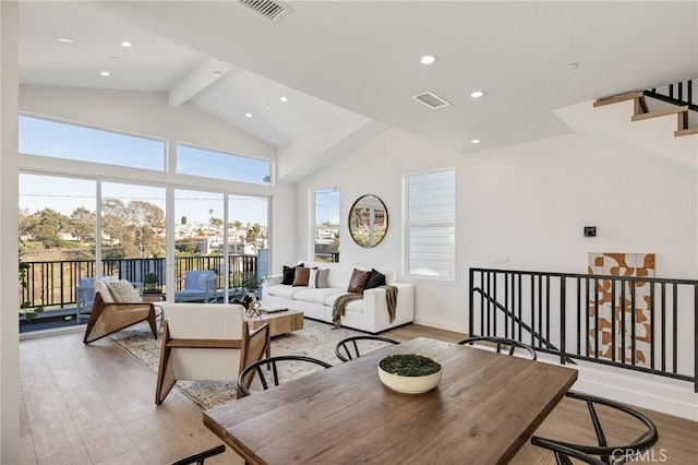 living room featuring light wood-style floors, visible vents, beamed ceiling, and recessed lighting