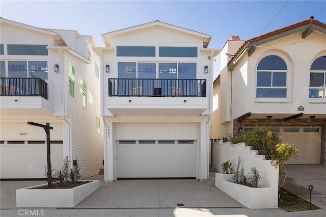 view of front of house with driveway, an attached garage, and a balcony