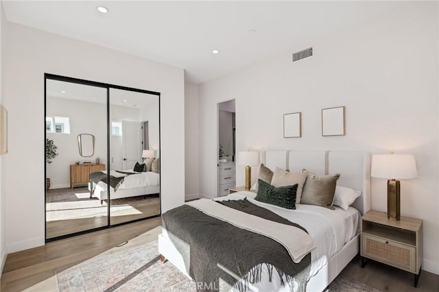 bedroom featuring a closet, visible vents, wood finished floors, and recessed lighting