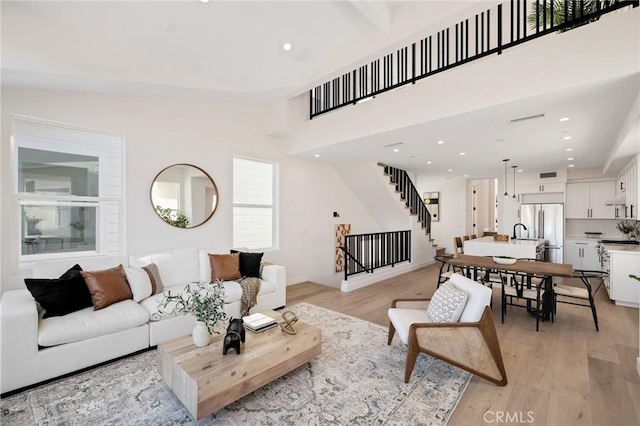 living area with light wood-style floors, stairs, visible vents, and recessed lighting