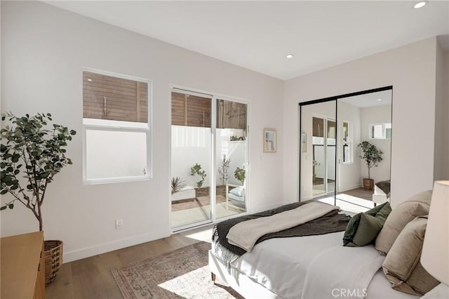 bedroom featuring baseboards, wood finished floors, access to exterior, a closet, and recessed lighting