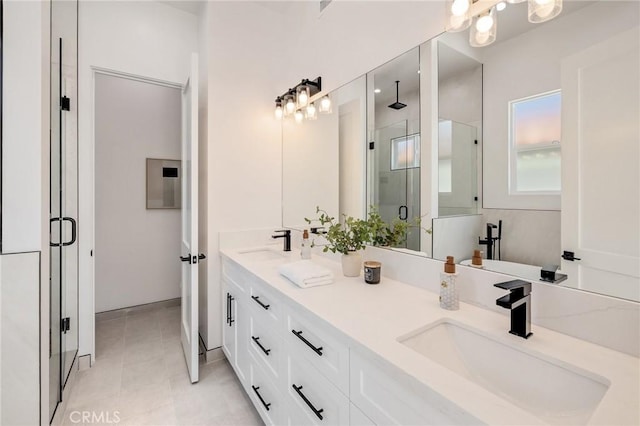 full bathroom featuring double vanity, a stall shower, tile patterned flooring, and a sink