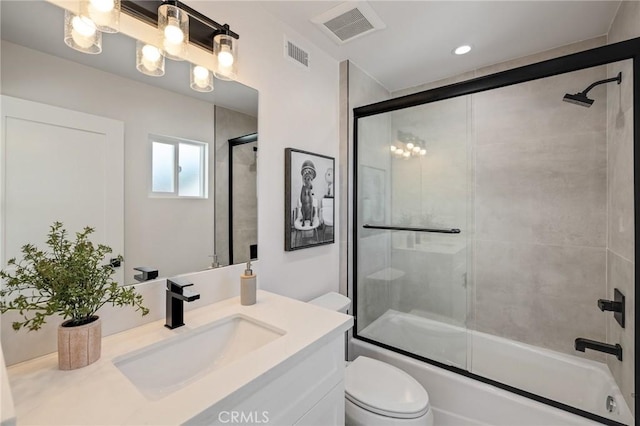 full bath featuring toilet, shower / bath combination with glass door, visible vents, and vanity