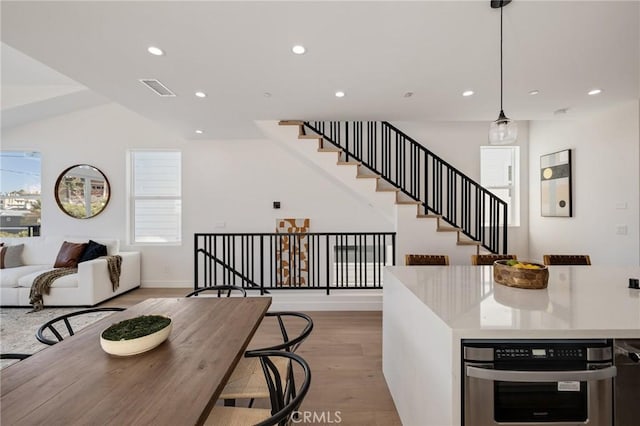 kitchen featuring visible vents, light wood-style flooring, open floor plan, light countertops, and recessed lighting