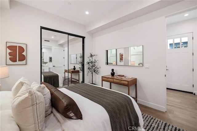 bedroom with light wood-style floors, baseboards, and recessed lighting