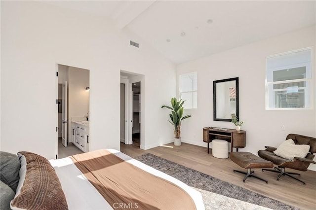 bedroom featuring high vaulted ceiling, wood finished floors, visible vents, a spacious closet, and beam ceiling