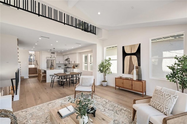 living area with light wood finished floors, baseboards, and recessed lighting