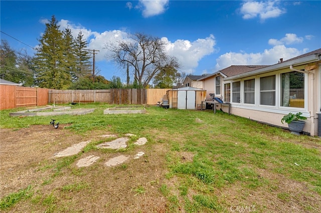 view of yard with an outbuilding, a storage unit, and a fenced backyard