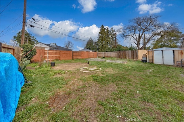 view of yard with a fenced backyard, an outdoor structure, and a storage unit