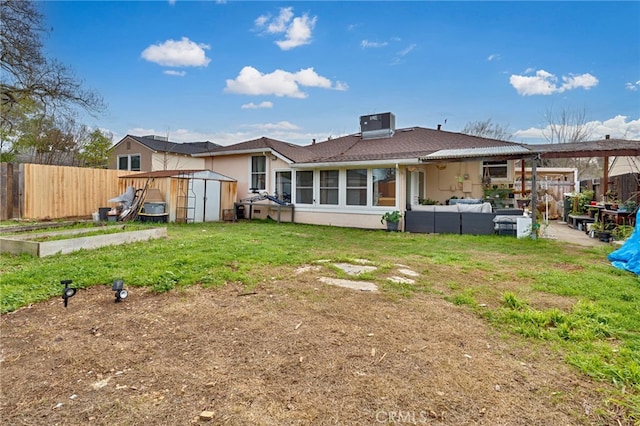 back of property featuring a garden, fence, an outdoor structure, a shed, and stucco siding