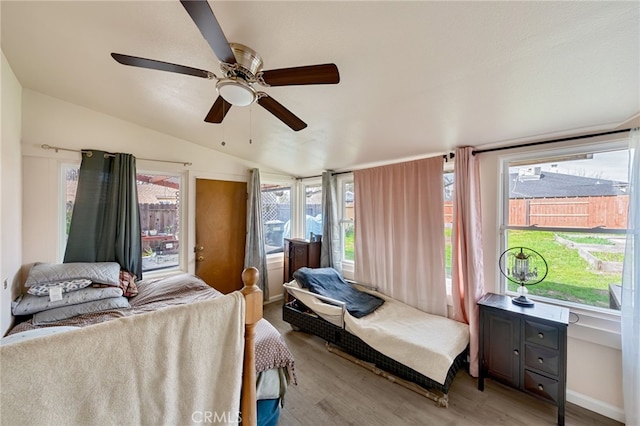 bedroom with lofted ceiling, light wood finished floors, and a ceiling fan