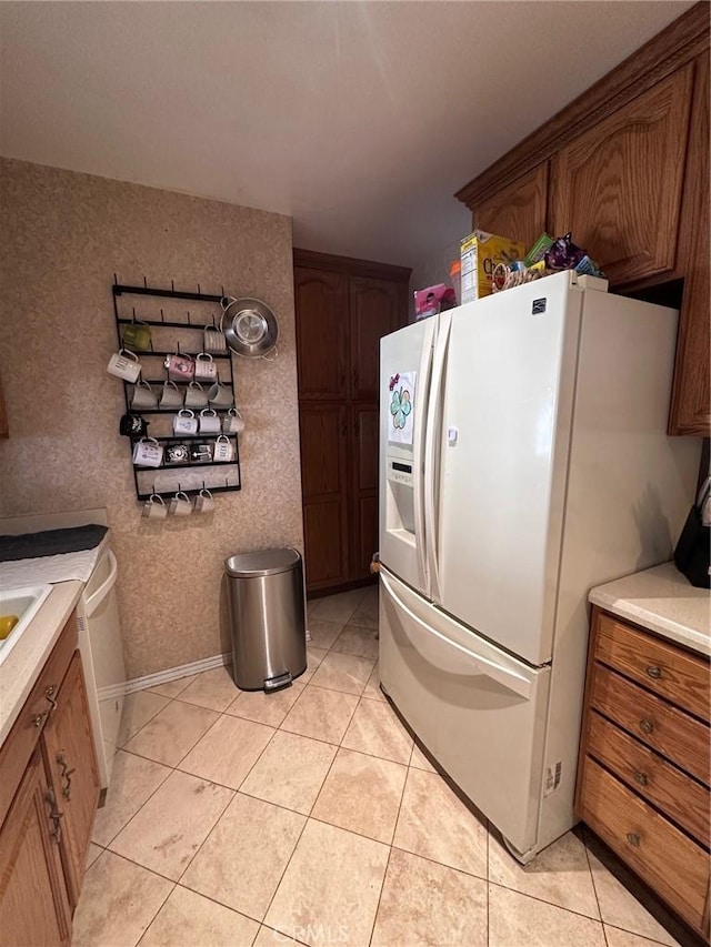 33518 Colorado St, Yucaipa, CA 92399 - kitchen featuring baseboards, light countertops, light tile patterned floors, white fridge with ice dispenser, and brown cabinetry