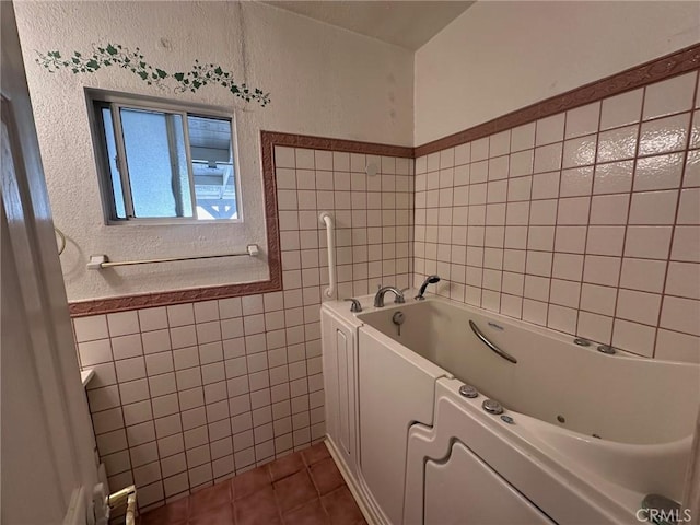 33518 Colorado St, Yucaipa, CA 92399 - full bathroom with tile patterned flooring, a tub with jets, tile walls, and a textured wall