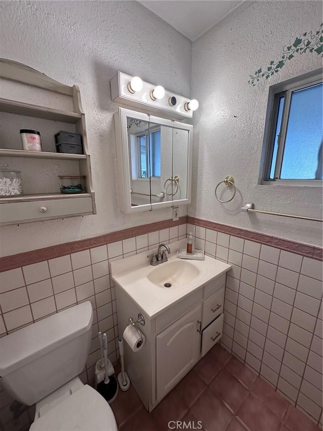 33518 Colorado St, Yucaipa, CA 92399 - half bath with tile patterned flooring, tile walls, toilet, and a wainscoted wall