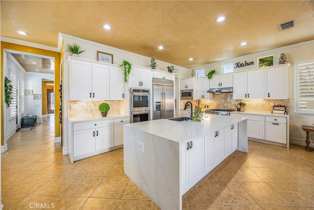 kitchen featuring light tile patterned floors, visible vents, built in appliances, under cabinet range hood, and a sink