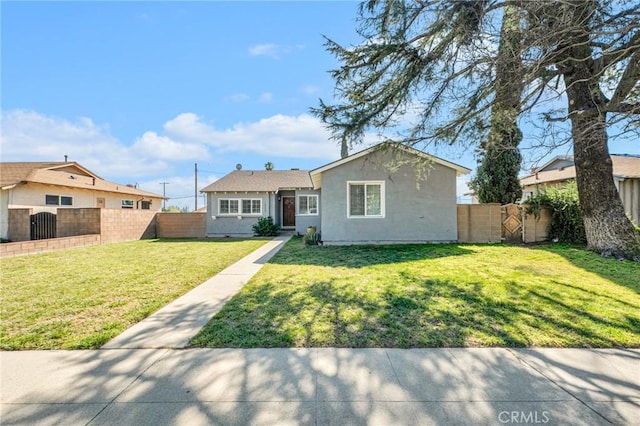 view of front of home featuring fence private yard, stucco siding, and a front yard