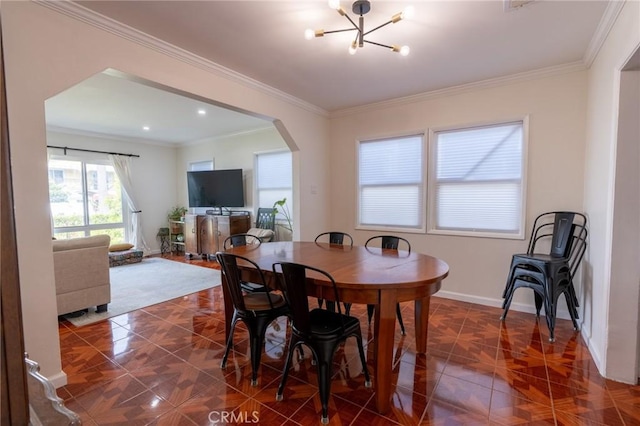 dining room featuring baseboards, a notable chandelier, arched walkways, and ornamental molding