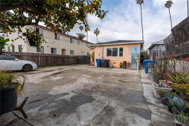 rear view of property featuring stucco siding, a patio, and fence private yard