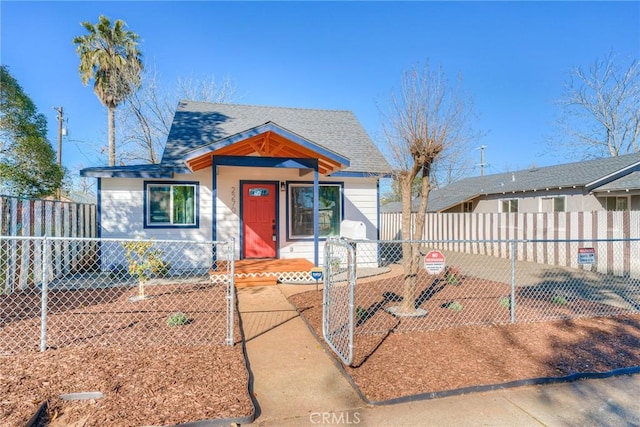 bungalow-style house featuring a fenced front yard, a gate, and a shingled roof