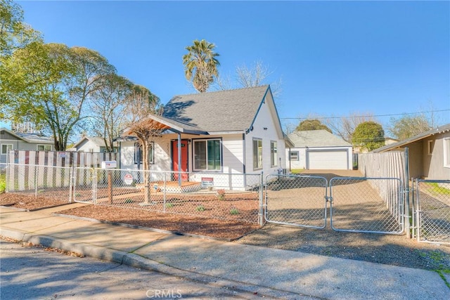 bungalow-style house with a shingled roof, a fenced front yard, a detached garage, and a gate