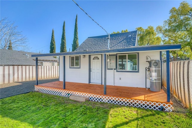 rear view of property with a yard, fence, and a wooden deck