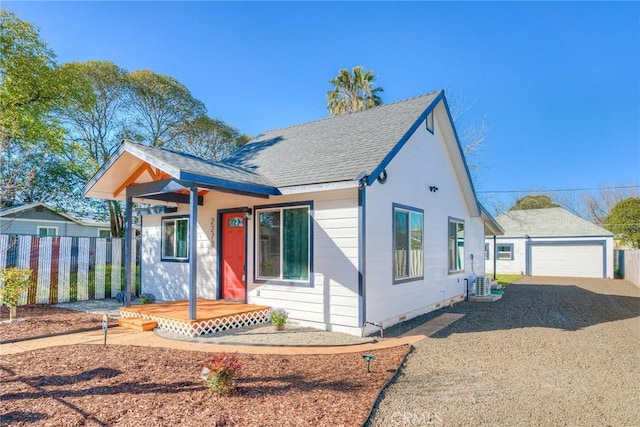 bungalow with a shingled roof, fence, and a detached garage