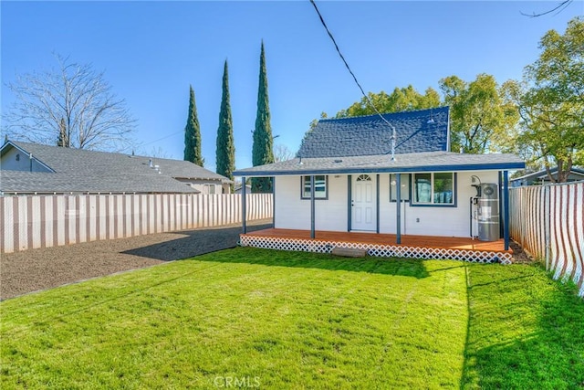 back of property with a fenced backyard, a porch, and a lawn