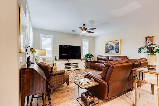 living room with a ceiling fan and light wood-type flooring