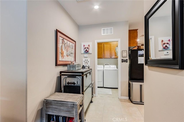 hallway featuring recessed lighting, washing machine and dryer, visible vents, and light tile patterned flooring