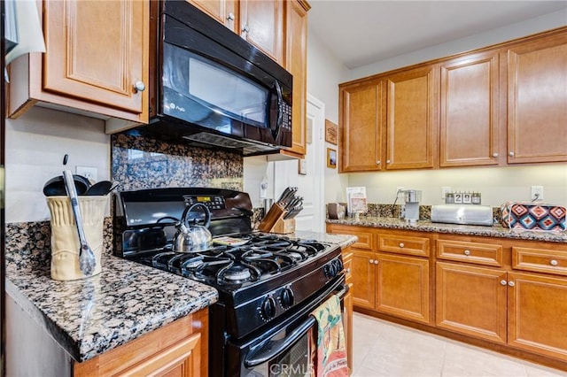 kitchen featuring black appliances, light stone counters, brown cabinets, and light tile patterned flooring