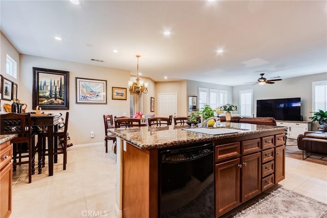 kitchen with stone counters, black dishwasher, visible vents, and a sink