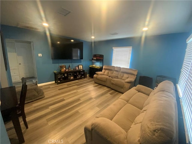 living area featuring baseboards, wood finished floors, and recessed lighting