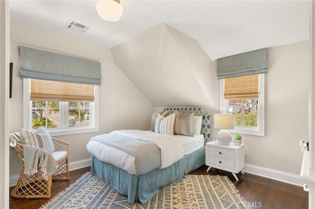 bedroom with dark wood-type flooring, multiple windows, visible vents, and baseboards