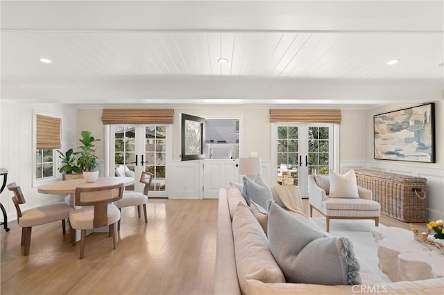 living room with light wood finished floors, french doors, wood ceiling, and a wealth of natural light