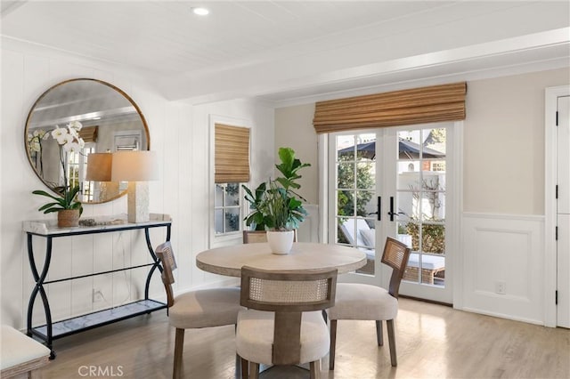 dining room with french doors, beam ceiling, recessed lighting, a decorative wall, and wood finished floors