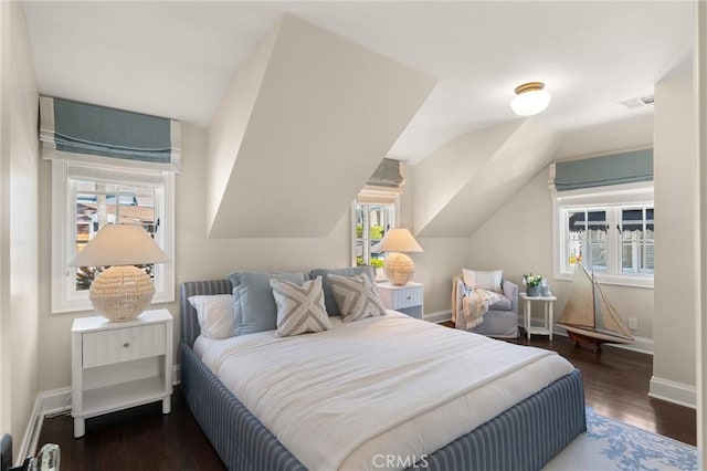 bedroom with dark wood-style floors, lofted ceiling, visible vents, and baseboards