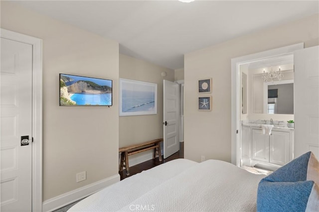 bedroom featuring a sink, ensuite bath, and baseboards