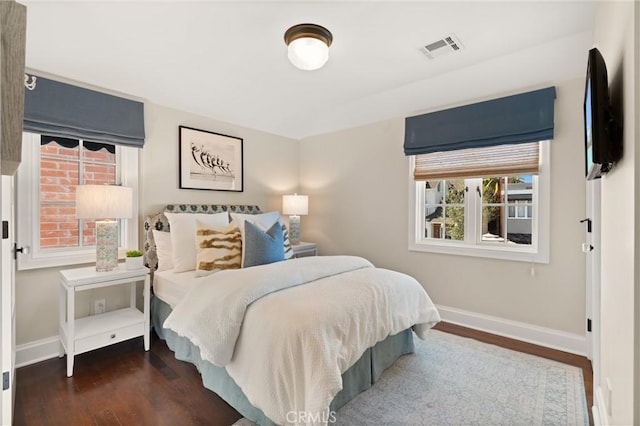 bedroom with baseboards, visible vents, and dark wood-type flooring