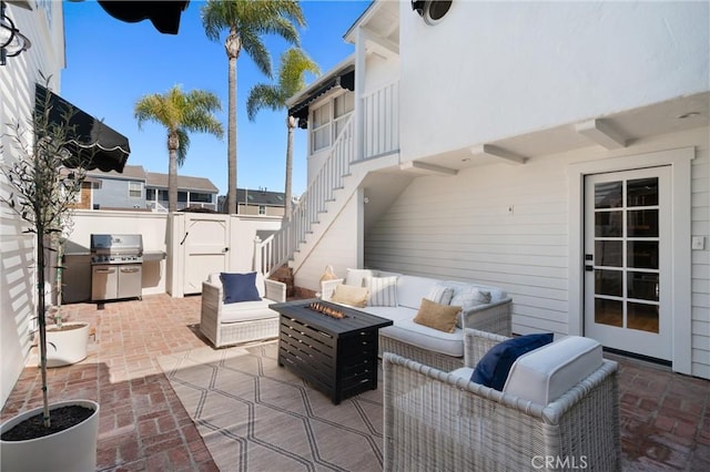 view of patio / terrace featuring a grill, stairway, and an outdoor living space with a fire pit