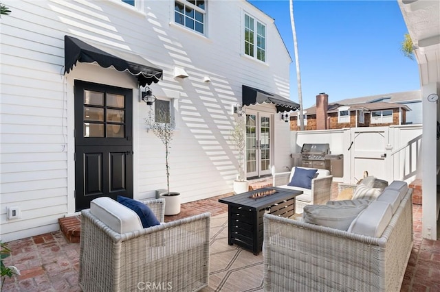 view of patio featuring area for grilling and an outdoor living space with a fire pit