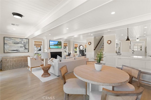 dining area with a wealth of natural light, a fireplace, visible vents, and crown molding