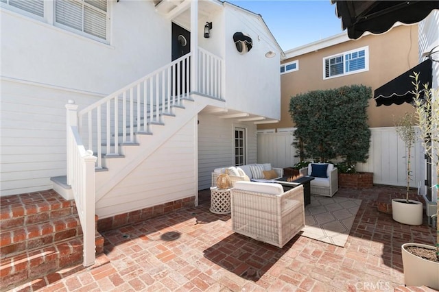 view of patio / terrace with stairway, fence, and an outdoor living space